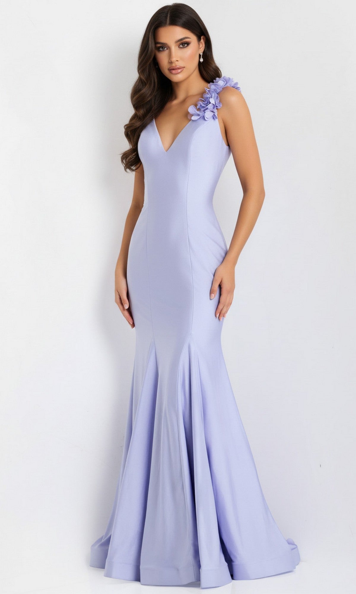A woman stands against a plain background wearing the Jovani 48120, a floor-length fitted lavender mermaid prom dress with a deep V-neckline and 3D floral appliques on one shoulder.